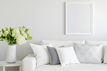 A minimalist living room featuring a white couch, decorative pillows, and a vase of flowers against a light wall, ready for art placement.