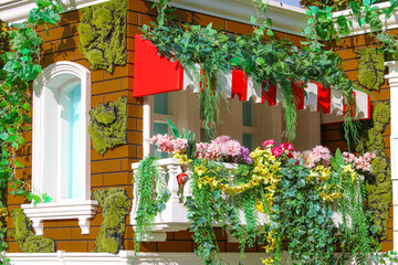 A brick building with a window surrounded by flowers and ivy
