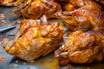 Whole chickens roasted on wooden charcoal barbecue grill