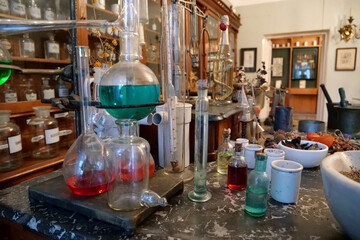 Chemistry beakers,bottles and flasks with liquids in laboratory of old pharmacy