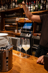 Pouring of txakoli or chacolí slightly sparkling very dry white wine produced in Spanish Basque Country in typical pinchos bar in old part of San Sebastian or Donostia, Spain