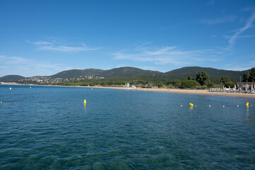 Morning view on crystal clear blue water of Plage du Debarquement white sandy beach near Cavalaire-sur-Mer and La Croix-Valmer, summer vacation on French Riviera, Var, France