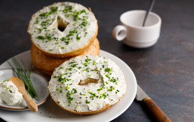 Breakfast table with bagels fresh cheese.
