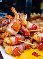 Typical snacks of Basque Country, pinchos or pinxtos skewers with small pieces of bread, fish, sea food, sweet green pepper served in bar in San-Sebastian or Bilbao, Spain