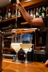 Pouring of txakoli or chacolí slightly sparkling very dry white wine produced in Spanish Basque Country in typical pinchos bar in old part of San Sebastian or Donostia, Spain