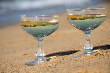 Summer time on French Riviera, two coupe glasses of champagne cremant sparkling wine on Pampelonne sandy beach near Saint-Tropez in sunny day, Var, vacation in France