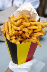 Belgian street and fast food, paper cone bag in colors of Belgian flag with fried potato frit chips...