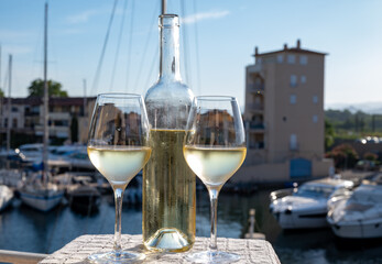 Glasses of cold white Cote de Provence wine in yacht harbour of Port Grimaud, summer vacation on French Riviera in Provence, France, wine tasting