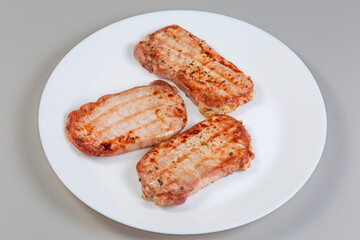 Grilled boneless pork chops with spices on the white dish