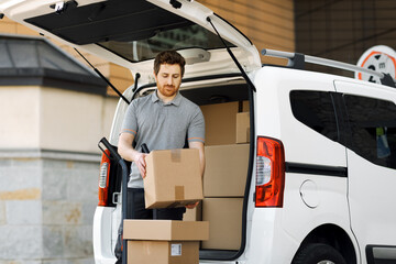 Professional delivery man loading packages on a hand truck