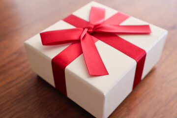 机の上に置いた赤リボンのプレゼントボックス