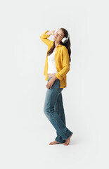 Happy trendy woman wearing headphones and dancing