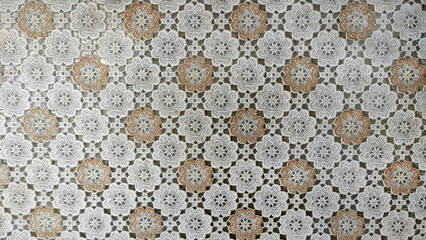 Delicate Floral Crochet Pattern: A close-up of a vintage crocheted tablecloth featuring a delicate floral pattern in cream and brown hues.