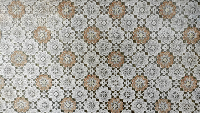 Delicate Floral Crochet Pattern: A close-up of a vintage crocheted tablecloth featuring a delicate floral pattern in cream and brown hues.