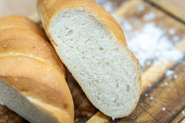 A loaf of sourdough bread on a wooden table, in a cut. a loaf of artisan bread.