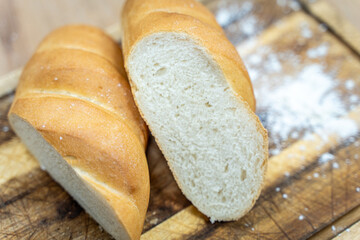 A loaf of sourdough bread on a wooden table, in a cut. a loaf of artisan bread.