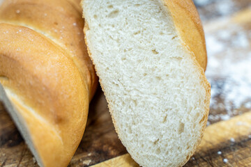 A loaf of sourdough bread on a wooden table, in a cut. a loaf of artisan bread.
