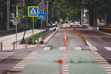 City street with many trees. new traffic safety speed bump on an asphalt road with pedestrian...