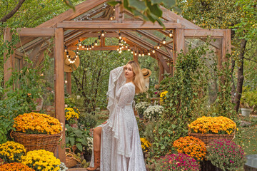 American blonde Woman in long white lace Boho dress with sleeves and fringe, fashionable outfit...