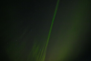  Soft green aurora borealis streaks gently across a starry night sky, creating a serene and...