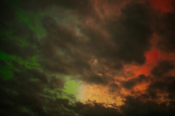 A captivating scene of the Aurora Borealis with vibrant red and orange hues illuminating the night sky. Dark clouds add drama, while subtle green light emerges through the atmosphere