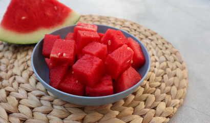 A bowl of fresh watermelon served on white bowl on wooden image. Breakfast fruit in the morning,...