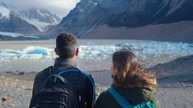 Travelers couple look at the mountain lake. Adventure and travel in the mountains region Patagonia, Fitz roy Mountain. 4k
