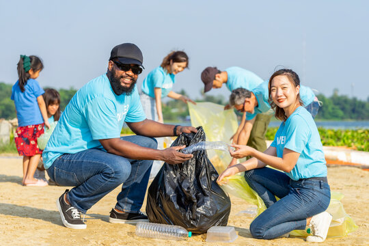 A diverse group of volunteers join together to cleanup the sand beach,collect garbage,separate waste.concept of global warming issue,reduce the impact of waste on the environment,save the planet