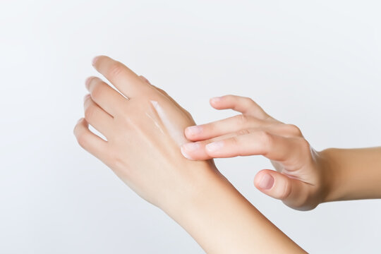 a woman applies cosmetic cream on her hands. hand skin care concept