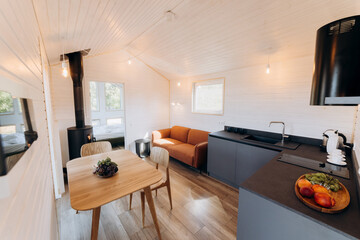 Modern open-concept kitchen and living area with natural light, cozy seating, and warm wooden design