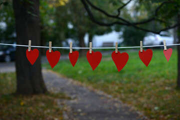 Heart shaped paper Pink color hanging on a rope with copy space for text Valentine's Day concept