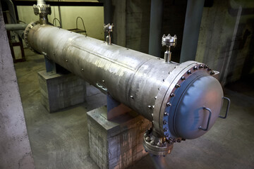 Industrial refinery 1 pass heat exchanger chiller with flanges and valves inside industrial workshop. Interior of enterprise industrial background with copyspace.