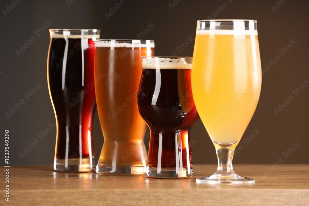 Poster Glasses with different types of beer on wooden table indoors, closeup