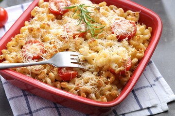 Delicious al forno pasta in baking dish on grey table