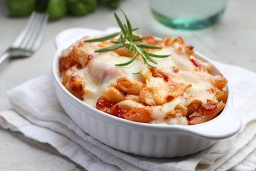 Delicious al forno pasta in baking dish on light table, closeup