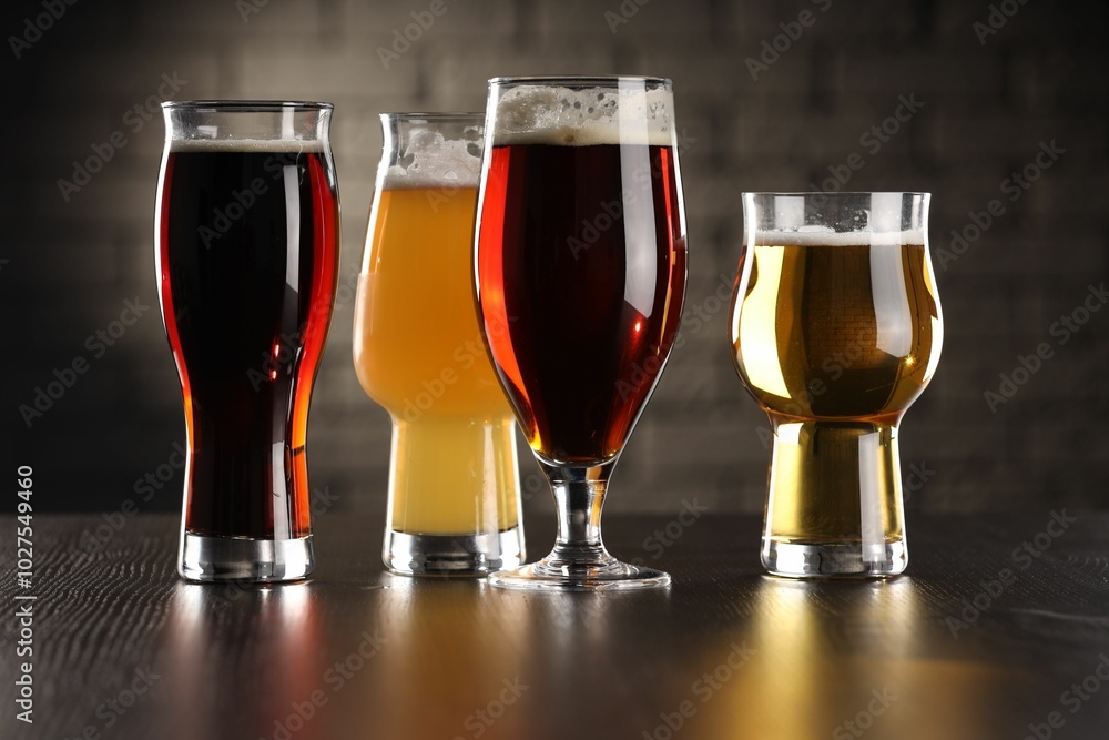 Sticker Glasses with different types of beer on wooden table in bar