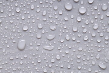 Water drops on gray background, top view