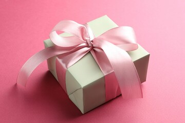 Beautiful gift box with bow on pink background, closeup