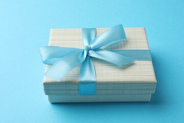 Gift box with bow on light blue background
