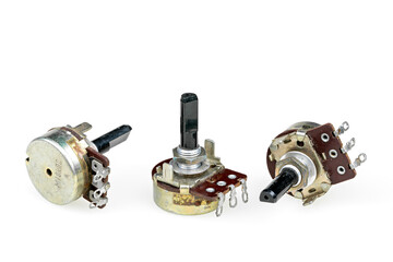 Close-up of three old adjustable potentiometers or variable resistor, isolated on a white...