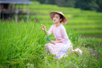 Beautiful women standing in a lush green tea field, likely in a rural area. They are wearing...