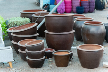 Fototapeta premium Stacked ceramic and clay pots in a pottery shop showcase a variety of terracotta planters and decorative garden containers. These eco-friendly pots add rustic charm to any garden or backyard decor.