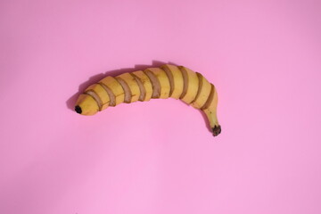 A close-up of a single banana, showcasing its smooth yellow peel with subtle brown spots. The texture and gentle curves highlight its ripeness, making it a simple yet vibrant representation of natural