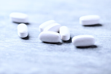 Amino acids tablets. Nutrition for bodybuilding. Fitness supplements on bright wooden background. Soft focus. Copy space.	