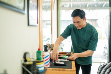 In a lively barber shop, a skilled man is expertly cutting another mans hair, showcasing his craft and professionalism in the process