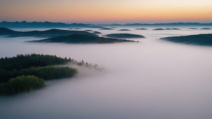 Fototapeta premium A breathtaking aerial view of islands covered in dense forest, surrounded by thick layers of fog floating over a serene lake. The mist blankets the valleys between the hills, creating a surreal, other