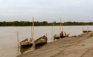 Gorai-Madhumati River. Riverside of Bangladesh. In the evening, fishing boats are moored on the river bank. The river flows under the twilight sky.