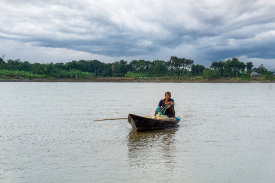Gorai-Madhumati river of Bangladesh. Evening by the river. Fishermen are fishing in boats in the middle of the river. The river flows under the twilight sky.