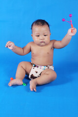 Adorable one year old Asian baby boy, playing lato lato style