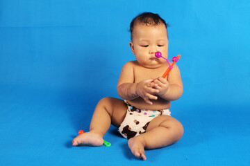 Adorable one year old Asian baby boy, playing lato lato style